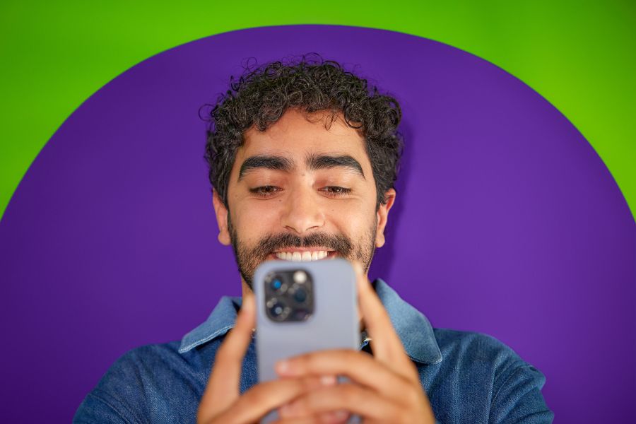 Man kijkt lachend op zijn telefoon