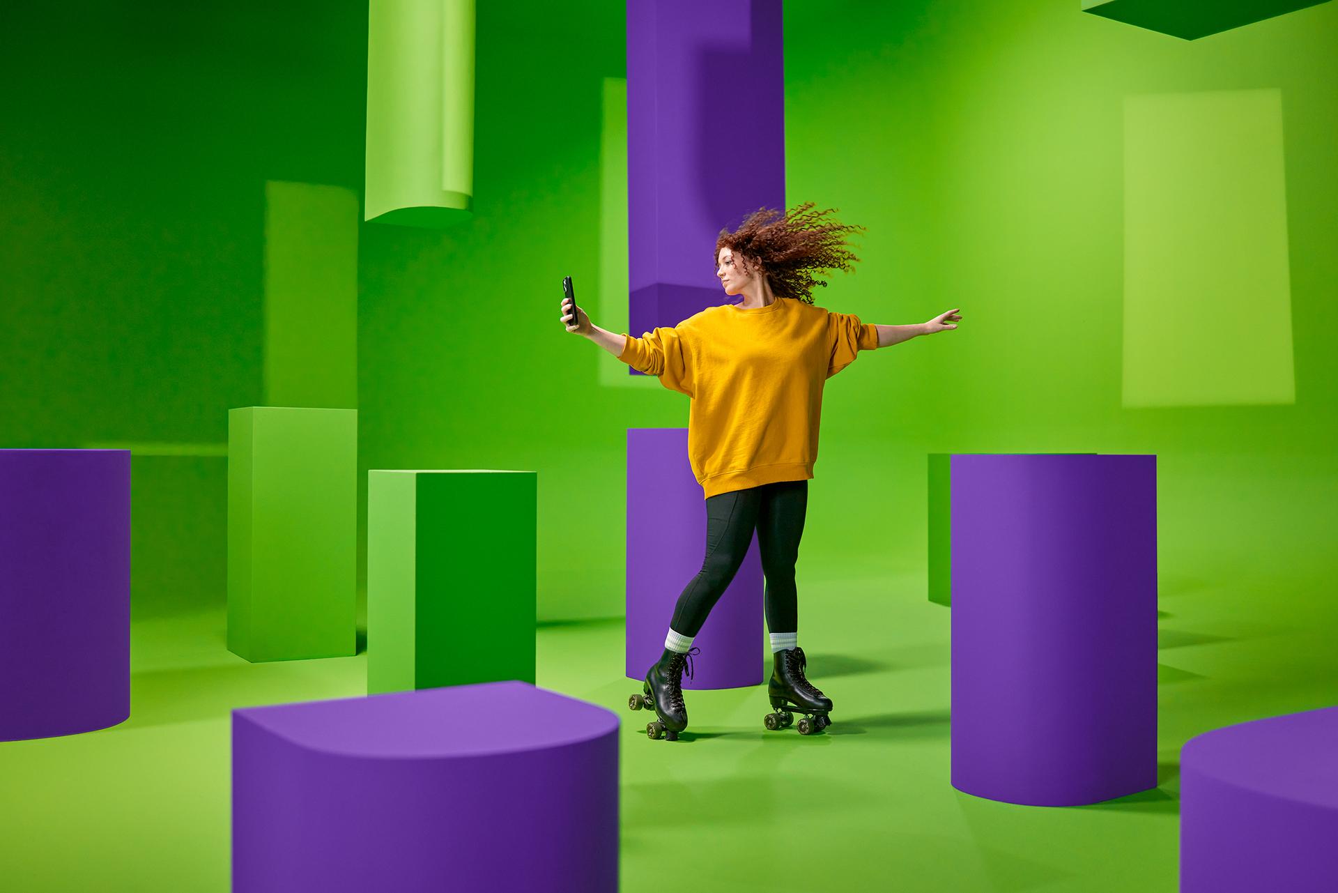 Vrouw in gele trui op rolschaatsen maakt selfie