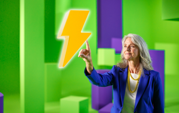 Vrouw met witte blouse en blauw jasje wijst naar gele bliksemflits